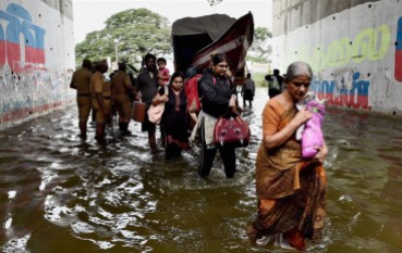 Chennai: People move from their waterlogged houses following heavy rains in Chennai on Tuesday. PTI Photo (PTI11_17_2015_000183B) via Indian Express